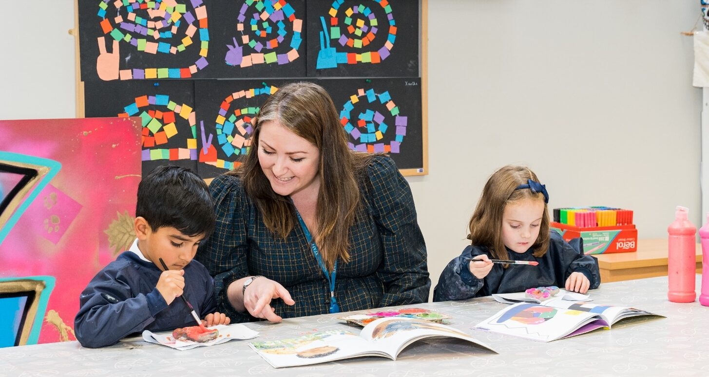 Laura Lamont, Head of Ardingly Prep and Nursery, helping two prep school children with painting.